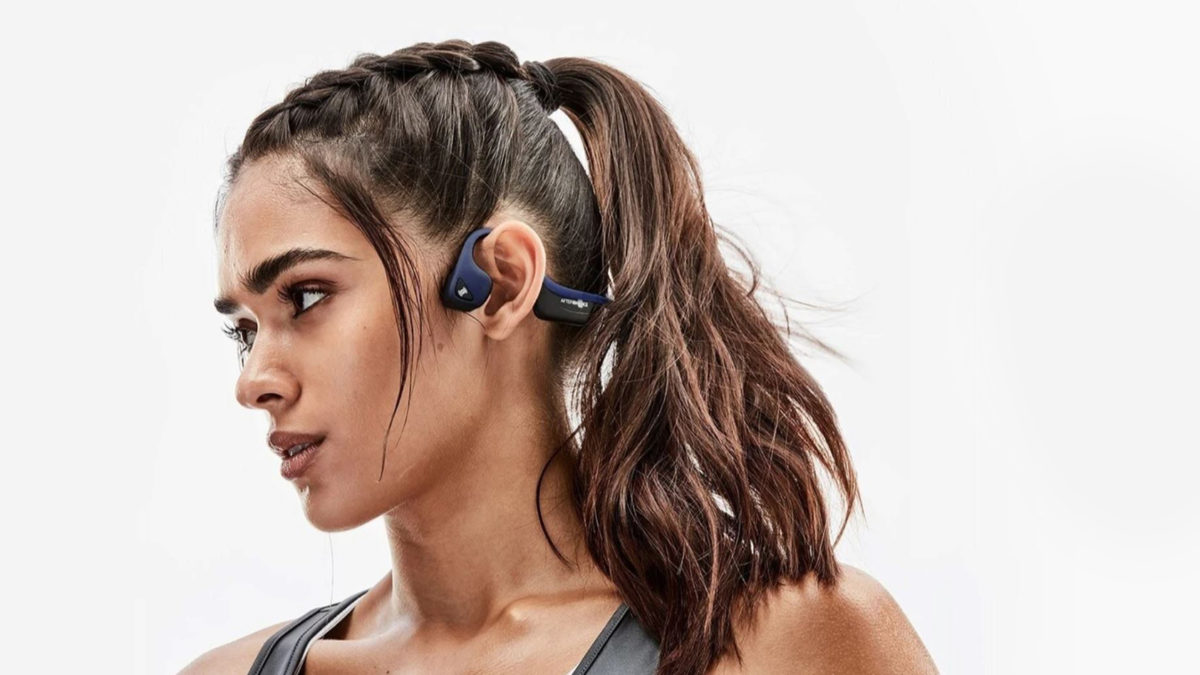 A picture of a woman in profile wearing the AfterShokz Air bone conduction headphones.