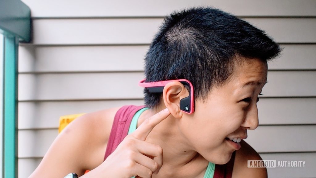 A picture of the Aftershokz titanium bone conduction headphones being worn by a woman in profile.