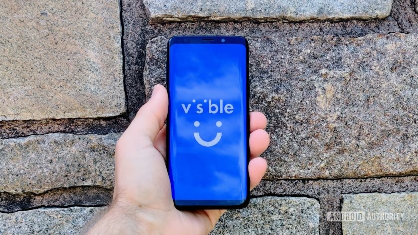 A Samsung Galaxy S9 in front of a brick wall with the Visible logo on the display.