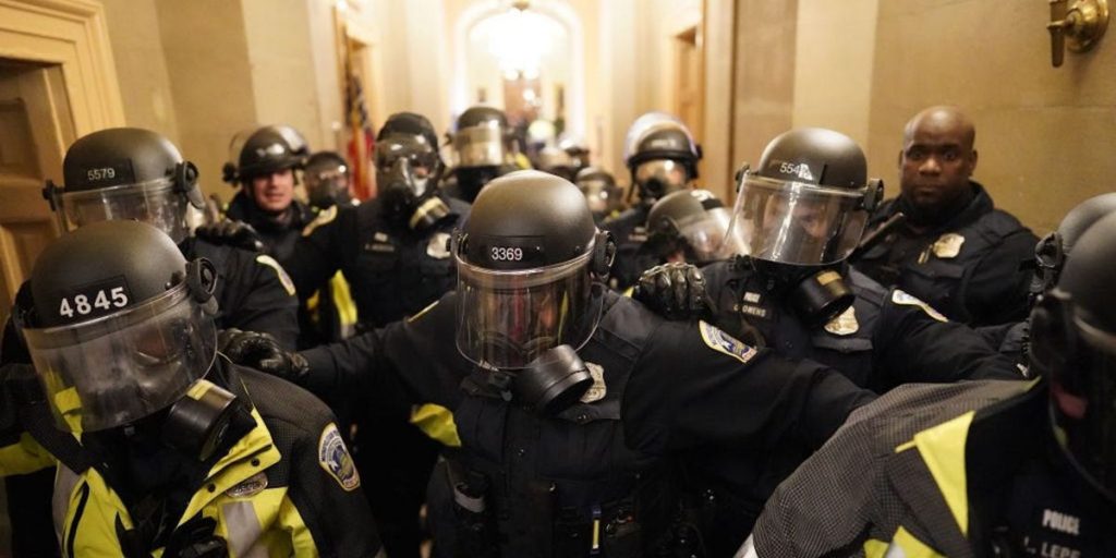 Video from the Capitol riot shows police officers being crushed in the doorway