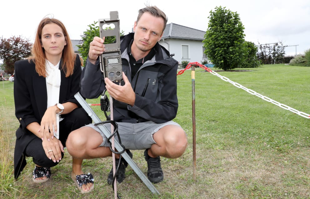 Benjamin E. (38) and his partner Jana (36) show off the wildlife camera a wolf consultant installed on their property and secured against theft with a bike lock.